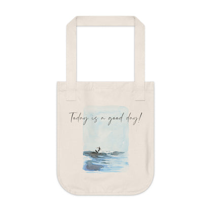 An organic cotton canvas tote bag with a printed watercolor illustration of a surfer and custom text. Personalized Surfing Design on Organic Cotton Canvas Tote Bag with customizable text. Perfect on-the-go tote bag for running errands or day trips to the beach. Gift idea for family, friend or yourself. Custom tote bag.