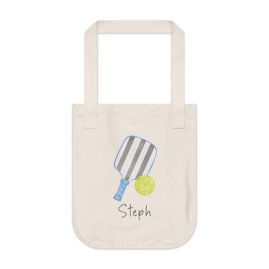 Pickleball player's personalized tote bag. An organic cotton canvas tote bag with a printed illustration of a striped pickleball paddle and a yellow pickleball, with customizable text written below, such as "Smash it!". Custom and personalized tote.